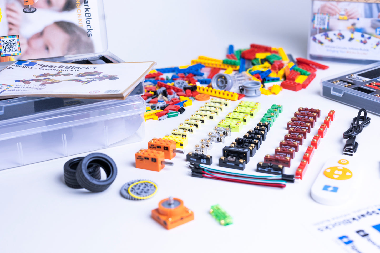 Assorted SparkBlocks building blocks and components on a white surface with manuals in the background.