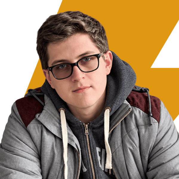 A young man with short brown hair and black-rimmed glasses, wearing a gray zip-up hoodie under a gray hooded jacket with maroon shoulder panels, posed against a graphic background of yellow and white.