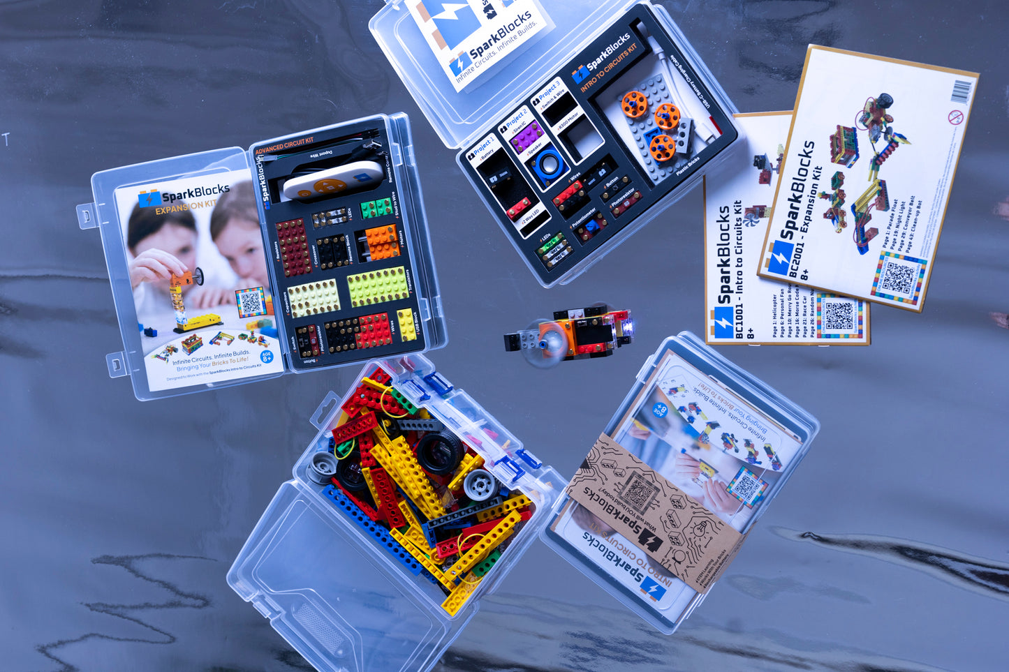 A collection of the Family Bundle's educational blocks for kids, featuring colorful components and circuit building parts on a reflective surface as part of a hands-on STEM kit.
